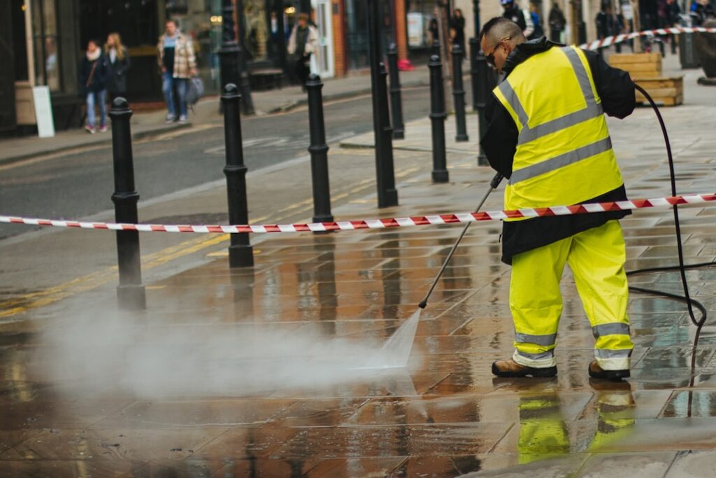 Worker pressure washing a paved walkway