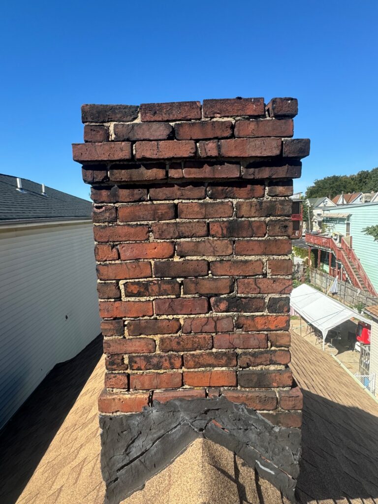 Chimney before repair with worn brickwork